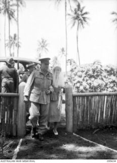 RABAUL, NEW BRITAIN, 1946-01-05. PRIVATE BARBARA JAMES, AUSTRALIAN ARMY MEDICAL WOMEN'S SERVICE, BEING ESCORTED UP THE PATH TO THE SACRED HEART CHAPEL BY COLONEL J. J. BLACK, COMMANDING OFFICER 118 ..