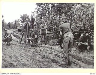 MAMAGOTA AREA, BOUGAINVILLE. 1945-07-22. THE SURVEY TEAM OF 3 SURVEY BATTERY, ROYAL AUSTRALIAN ARTILLERY, TAKING OBSERVATIONS AT A TRAVERSE STATION WITH THE THEODOLITE. MEMBERS OF THE TEAM ARE ..