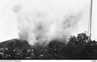PORT MORESBY, NEW GUINEA. 1942-03-19. THICK SMOKE BILLOWS UP FROM TUAGUBU HILL AFTER A JAPANESE AIRCRAFT ATTACK AGAINST A 3.7 INCH ANTI-AIRCRAFT BATTERY