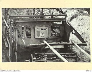 HANSA BAY, NEW GUINEA. 1944-06-19. THE CABIN OF A BURNT OUT JAPANESE ARMY 6 WHEEL TRUCK DUG IN, IN A BOMB BLASTED COCONUT PLANTATION. THIS VEHICLE WAS USED AS A RADIO VAN AND FOR CABLE LAYING ..