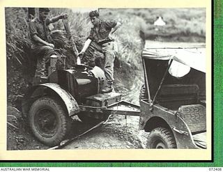 GUY'S POST, NEW GUINEA. 1944-04-16. NX60432 DRIVER A.E. WHITBY (1), WITH VX13293 DRIVER R.N. FOGARTY (2), MEMBERS OF THE 153RD GENERAL TRANSPORT COMPANY, FILL A WATER TRAILER FROM A WATERING POINT. ..