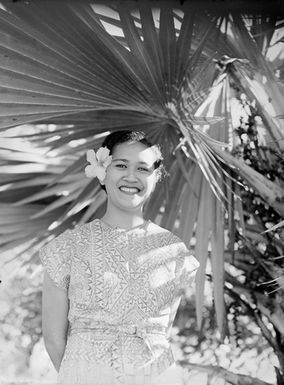 [Half-length portrait of a young Pacific island woman with a flower in her hair]