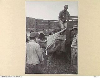 MUSCHU ISLAND, NEW GUINEA. 1945-09-11. JAPANESE SOLDIERS UNLOADING THE FIRST OF RATIONS SUPPLIED BY HEADQUARTERS 6 DIVISION TO JAPANESE PERSONNEL. THE RATIONS CONSISTED OF RICE, TEA, SUGAR, BULLY ..