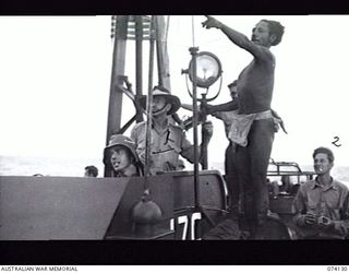 BLUP BLUP ISLAND, NEW GUINEA. 19 JUNE 1944. A NATIVE GUIDE INDICATING A PASSAGE THROUGH THE REEF TO THE CAPTAIN OF A UNITED STATES NAVY TORPEDO BOAT WHICH IS CARRYING A PATROL OF MEMBERS OF A ..