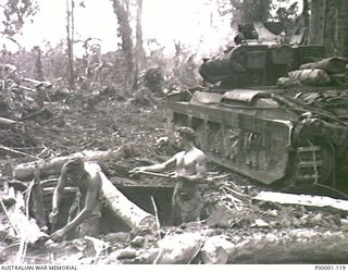 THE SOLOMON ISLANDS, 1945-04-24/27. TANK CREW MEMBERS OF 2/4TH AUSTRALIAN ARMOURED REGIMENT DIGGING A POSITION WITH THEIR MATILDA TANK BESIDE THEM ON BOUGAINVILLE ISLAND. (RNZAF OFFICIAL ..