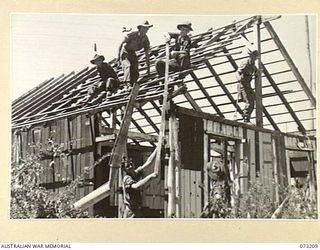 ALEXISHAFEN, NEW GUINEA. 1944-05-15. TROOPS OF THE 2/15TH FIELD AMBULANCE RE-BUILDING A WRECKED SECTION OF THE CATHOLIC MISSION. THE MISSION HAS RECEIVED DAMAGE FROM BOTH ALLIED AND JAPANESE ..