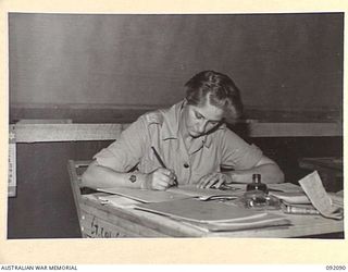 LAE, NEW GUINEA, 1945-05-21. WARRANT OFFICER T.M. LAIRD, COMPANY SERGEANT MAJOR, MARKING ROLLS IN THE ORDERLY ROOM AT THE AUSTRALIAN WOMEN'S ARMY SERVICE BARRACKS IN BUTIBUM ROAD