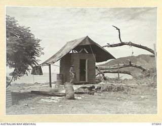 LAE, NEW GUINEA. 1944-05-28. Q271745 SAPPER C.D. HANDFORD, 5TH COMMANDER ROYAL ENGINEERS, (A.I.F.), STANDS OUTSIDE THE TENT COVERED COLDSTREAM REFRIGERATOR WHICH HAS BEEN INSTALLED AT THE ..