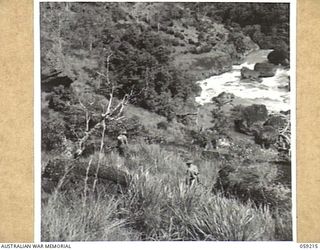 LALOKI VALLEY, NEW GUINEA, 1943-11-05. A PATROL OF THE NEW GUINEA FORCE TRAINING SCHOOL (JUNGLE WING) MOVING THROUGH ROUGH COUNTRY NEAR THE ROUNA FALLS