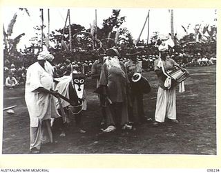 KARAVIA BAY, NEW BRITAIN. 1945-10-23. MAJOR GENERAL K.W. EATHER, GENERAL OFFICER COMMANDING 11 DIVISION, VISITED THE INDIAN EX-PRISONER OF WAR CAMP AT KARAVIA BAY. SHOWN, AN INDIAN SONG AND COMEDY ..