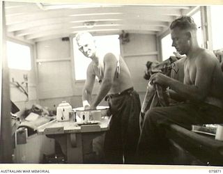 ALEXISHAFEN NORTH, POTSDAM AREA, NEW GUINEA. 1944-09-02. SX29669 PRIVATE A.D. WHITE (1) AND N242942 PRIVATE J. FOX (2), MEDICAL ORDERLIES ABOARD THE MEDICAL LAUNCH, AM1568 OF THE 4TH SEA AMBULANCE ..