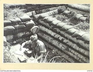 AITAPE, NEW GUINEA. 1945-03-16. A FULLERPHONE MK 4 (SPECIAL AUSTRALIAN PATTERN) SET USED IN LONG RANGE WORK FROM AN OPEN DUGOUT, OPERATED BY A MEMBER OF HEADQUARTERS 6TH DIVISION SIGNALS