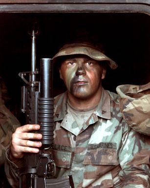 US Marine Corps Lance Corporal Andrew J. Wallace, armed with an M16A2 rifle with an M203 grenade launcher attached, waits for the time when he and his company arrive at Pacific Missile Range Facility, Barking Sands, Kauai, Hawaii, for a beach assault during RIMPAC '96