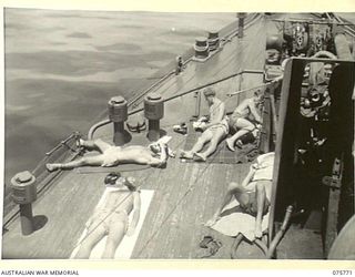 HUMBOLT BAY, NEW GUINEA. 1944-09/08. "OFF WATCH" RATINGS ENJOYING A GOOD SUNBAKE ON THE FORECASTLE OF THE RAN COVETTE, GEELONG