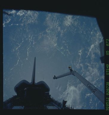 S49-85-073 - STS-049 - Dark views of RMS arm over payload bay