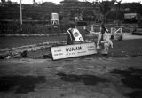 Guam, Harrison Forman, the photographer, next to a sign for 'Guam, Military Installation'