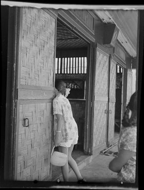 Street scene, woman standing in doorway of bar, Quinns Tahitian Hut, Tahiti