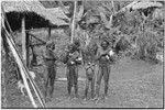 Fainjur: smoking men hold rolls of paper, other man and a boy