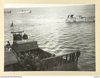 HOSKINS, NEW BRITAIN. 1944-10-08. UNITED STATES ARMY LCM (LANDING CRAFT MECHANISED) MOVING INTO THE BEACH LOADED WITH TROOPS OF THE 36TH INFANTRY BATTALION