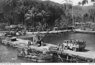 MILNE BAY, NEW GUINEA. 1944-03-04. TROOPS FROM TOWNSVILLE, QUEENSLAND, LEAVING IN TRUCKS AFTER DISEMBARKING AT LYALL WHARF