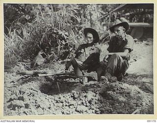 KARAWOP AREA, NEW GUINEA. 1945-04-19. PRIVATE F. ROMERO (1), AND PRIVATE R. REYNOLDS (2), GUARDING A TRACK FOR A FORWARD COMPANY OF 2/1 INFANTRY BATTALION