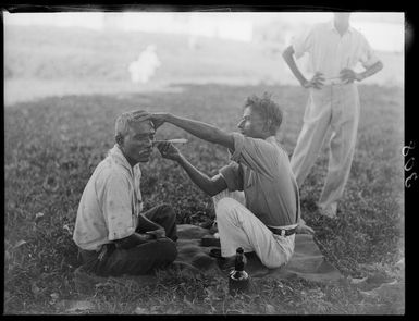 Unidentified Fijian Indian barber shaving an unidentified man, Fiji