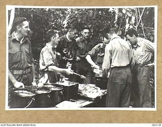 FINSCHHAFEN, NEW GUINEA. 1943-12-25. SENIOR NON COMMISSIONED OFFICERS OF HEADQUARTERS 9TH DIVISION SERVING CHRISTMAS DINNER TO THE TROOPS