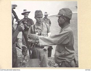 MOUNT SHIBURANGU, WEWAK AREA, NEW GUINEA. 1945-09-21. MAJOR GENERAL ARAKI OF 18 JAPANESE ARMY HANDING OVER HIS SWORD TO CAPTAIN M.B. LONG, HEADQUARTERS 6 DIVISION, AT A CONTROLLING POINT AT MAKOW ..