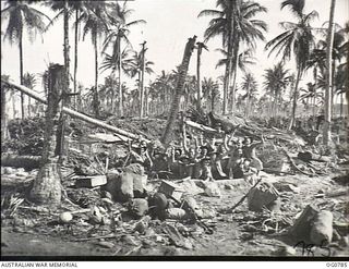 LOS NEGROS ISLAND, ADMIRALTY ISLANDS. 1944-03-18. INFORMAL GROUP PORTRAIT OF GROUND CREWS OF A RAAF KITTYHAWK SQUADRON IN FOXHOLES THEY DUG ON THE FIRST NIGHT THEY LANDED WHEN THE BATTLE FOR MOMOTE ..