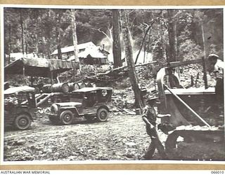 BULLDOG-WAU ROAD, NEW GUINEA. 1944-01-19. VX73646 SAPPER H.V. MORRIS (1) AND VX67271 SAPPER J. YOUNG (2) OF THE 2/4TH FIELD SQUADRON WORKING ON A D7 BULLDOZER AT THE 29 MILE CAMP