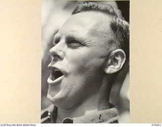 MILILAT, NEW GUINEA. 1944-08-23. TX14866 PRIVATE W.R. LYNE, VOCALIST OF THE "TASMANIACS", THE TASMANIAN LINES OF COMMUNICATION CONCERT PARTY, PRACTISING DURING A CONCERT REHEARSAL