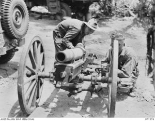 MASAWENG RIVER, NEW GUINEA. 1944-03-31. GUNNER JEWELL (1), AND GUNNER HAMERLL (2), MEMBERS OF THE 2/14TH FIELD REGIMENT PREPARE A CAPTURED JAPANESE 75MM GUN FOR A TEST SHOOT AT THE LIGHT AID ..