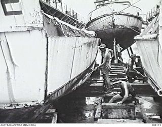 MANUS ISLAND, ADMIRALTY ISLANDS. 1949-09. VIEW OF THE INTERIOR OF DRY DOCK AD 301 WITH LANDING CRAFT UNDERGOING ROUTINE MAINTENANCE. IN THE BACKGROUND A LIGHTER RESTS ON THE BLOCKS. (NAVAL ..