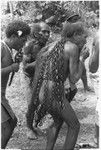 Alefo and his companions play pan-pipes in a sacred dance; Each woven link represents a successfully stolen pig