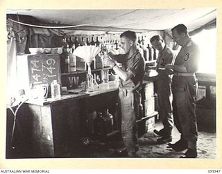 BORAM BEACH, WEWAK AREA, NEW GUINEA. 1945-08-31. PERSONNEL OF 2/15 FIELD AMBULANCE WORKING IN THE DISPENSARY. IDENTIFIED PERSONNEL ARE:- PRIVATE S. COUCILL (1); STAFF SERGEANT M. MCLENNAN (2); ..