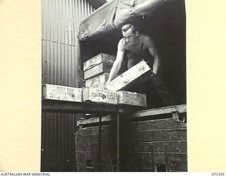 PORT MORESBY, NEW GUINEA. 1944-04-18. QX126911 PRIVATE B. STRATTOM, AUSTRALIAN ARMY SERVICE CORPS, LOADS A TRUCK WITH BONELESS BEEF FROM NO. 2 COLD STORE, ELA BEACH. THE SUPPLIES ARE TAKEN TO THE 4 ..