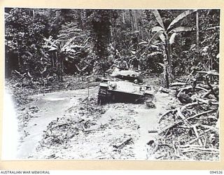 TOROKINA, BOUGAINVILLE, 1945-08-02. AN M24 GENERAL CHAFFEE LIGHT TANK CAUGHT ON A LOG; IT FAILED TO NEGOTIATE AN AREA IN WHICH A MATILDA TANK HAD BECOME BOGGED. THE M24 IS TAKING PART IN TRIALS ..