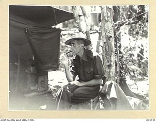 KILIGIA, NEW GUINEA, 1944-03-20. VX90176 SERGEANT R.J. BUCHANAN, PHOTOGRAPHER, AUSTRALIAN MILITARY HISTORY SECTION, LAND HEADQUARTERS, SMOKING HIS PIPE