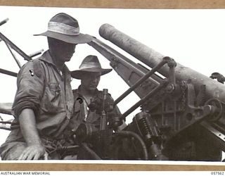 SALAMUA, NEW GUINEA. 1943-09-20. MEMBERS OF THE 162ND AUSTRALIAN LIGHT ANTI-AIRCRAFT BATTERY, AIF, EXAMINING A BOMB DAMAGED JAPANESE ANTI-AIRCRAFT GUN. SHOWN ARE:- QX49661 DRIVER A. M. ATHERTON ..