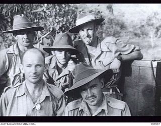 PORT MORESBY, NEW GUINEA, 1942-05-23. MEMBERS OF C PLATOON, 2/5TH INDEPENDENT COMPANY, WAITING AT SEVEN MILE AERODROME FOR THE AIRCRAFT WHICH IS TAKING THEM TO WAU. IDENTIFIED PERSONNEL ARE: ..
