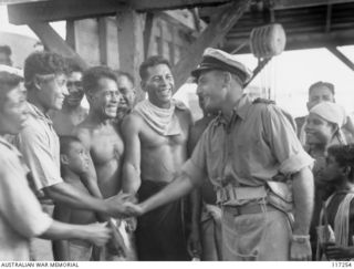 NAURU ISLAND. 1945-09-13. LIEUTENANT G. A. LORDING, INTELLIGENCE OFFICER, ROYAL AUSTRALIAN NAVY, RECEIVES AN ENTHUSIASTIC GREETING FROM THE NATIVES ON HIS ARRIVAL ON THE ISLAND