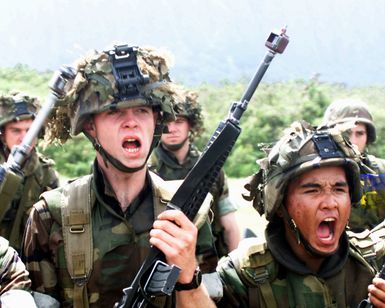 Marines from Charlie Company, 1ST Battalion, 3rd Marines, armed with M16 rifles yell commands to a fictitious crowd in preparation for crowds gathered around the mock embassy at the Bellows Training Area, Pohakuloa Training Area, Hawaii