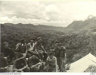 BOUGAINVILLE ISLAND. 1944-12-30. TROOPS OF THE 25TH INFANTRY BATTALION HAVING LUNCH ON THE CREST OF ARTILLERY HILL OVERLOOKING THE LARUMA VALLEY