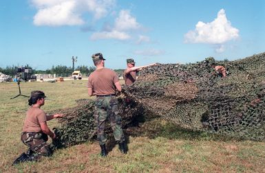 US Army (USA) personnel assigned to the 21st Signal Battalion, Fort Richardson, Alaska set up camouflaged netting use to cover the communication center at Orote Point, Guam during Exercise TANDEM THRUST 99