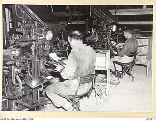 LAE AREA, NEW GUINEA. 1945-08-31. CORPORAL E.F.N. MCLEOD (1) AND PRIVATE E.J. JONES (2) LINOTYPE OPERATORS, WORKING ON THE PRODUCTION OF THE ARMY NEWSPAPER, GUINEA GOLD. BOTH LINOTYPE MACHINES ARE ..