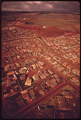 REZONING OF "SURPLUS PINEAPPLE LAND" ENABLED PINEAPPLE GROWERS-TURNED-DEVELOPERS TO BUILD THIS SUBDIVISION IN MILILANI TOWN, ONE SOLUTION TO THE ISLAND'S HOUSING SHORTAGE. FRESHLY CLEARED LAND WILL BECOME PART OF THE EXPANDING "NEW TOWN."