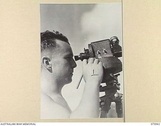 MILILAT, NEW GUINEA. 1944-09-14. 423607 SERGEANT F W BOYLE, 5TH METROLOGICAL DETACHMENT, RAAF, ATTACHED 5TH DIVISION, TAKING A READING ON A HYDROGEN FILLED BALLOON, WHICH HE HAS JUST RELEASED, TO ..