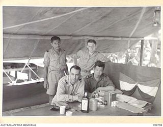 KERAVIA BAY, NEW BRITAIN. 1945-11-12. LIEUTENANT M.E. FRYN, OFFICER COMMANDING AND MEMBERS OF HIS STAFF AT THE CAMP OFFICE IN THE ROYAL NETHERLANDS EAST INDIES ARMY CAMP, WHERE SOME 150 ROYAL ..