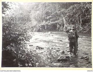 KIARIVU, NEW GUINEA, 1945-08-06. TROOPS OF 15 PLATOON, C COMPANY, 2/7 INFANTRY BATTALION MOVING ACROSS THE LAST NATURAL BARRIER TO THE EMERGENCY LANDING GROUND DURING THEIR TREK FROM BERIMU TO THE ..