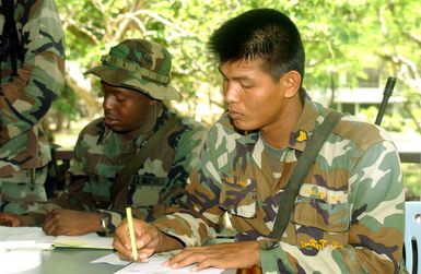 US Marine Corps (USMC) Lance Corporal (LCPL) Byron Martin, left and Royal Thai Marine Sergeant (SGT) Sayun Thangtong, use the Non-Combatant Evacuation Operation (NEO) tracking system to processes Evacuees during a NEO, part of Exercise COBRA GOLD 2003. Lance Corporal (LCPL) Byron Martin, is attached to the 3rd Brigade Service Support Group from Kaneohe Bay, Hawaii